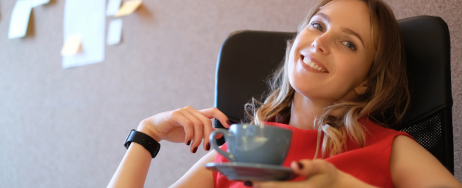 Effizientes Zeitmanagement - Frau, die in ihrem Büro in Ruhe einen Kaffee trinkt